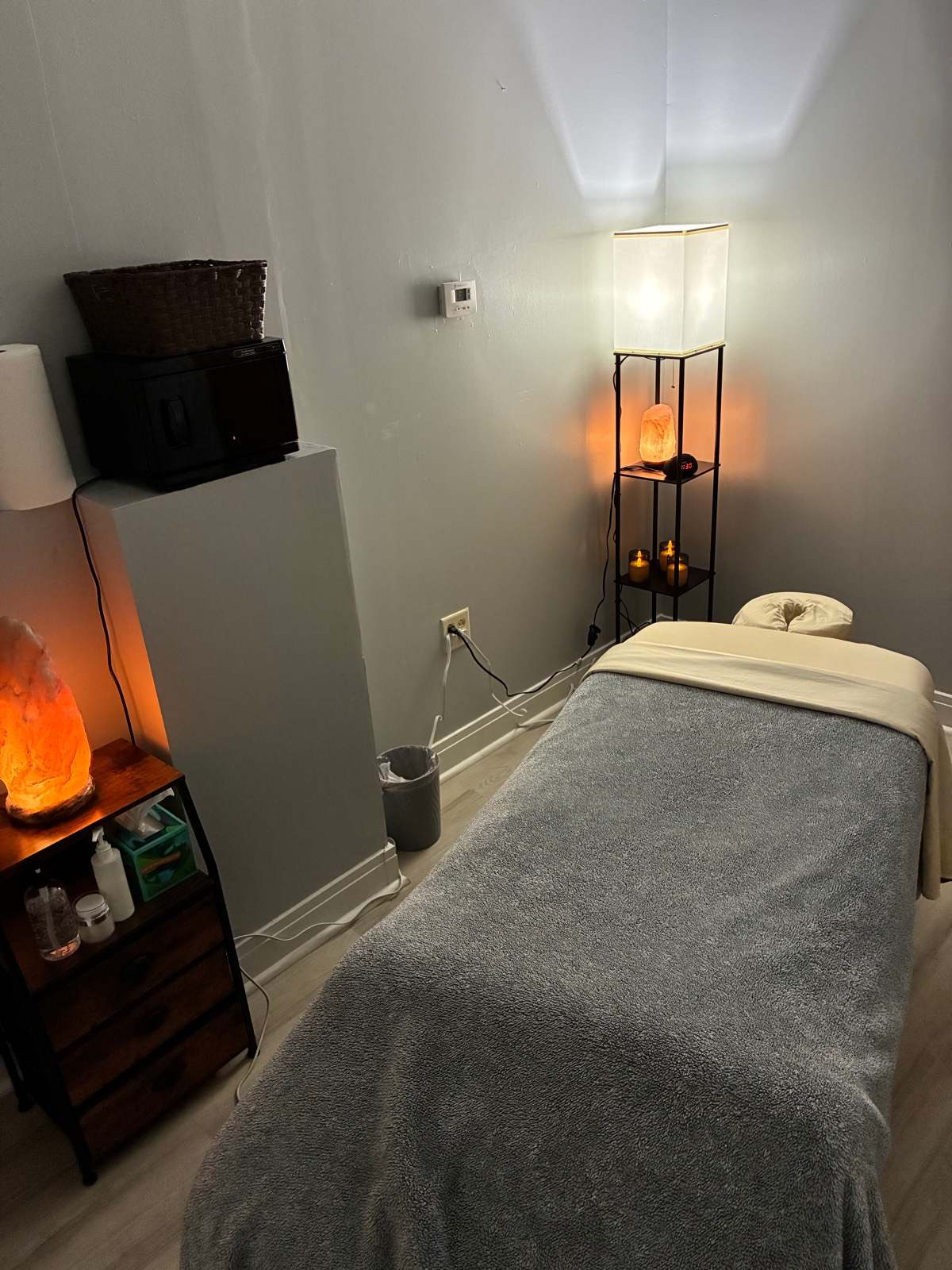 A private treatment room with a massage table, salt lamps and candles.